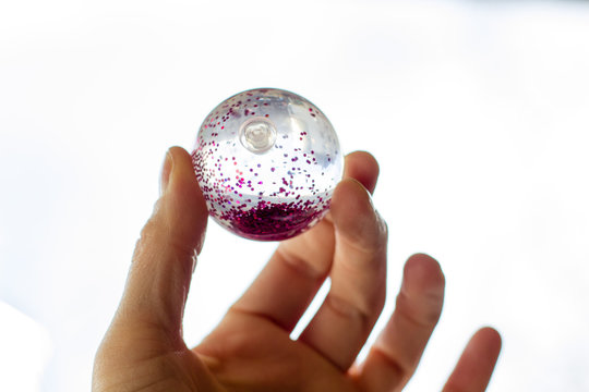 Flummi mit Glitter zwischen den Fingern