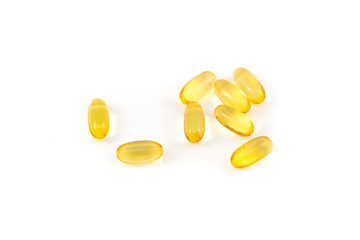 Shiny, yellow multivitamin softgels isolated on white background
