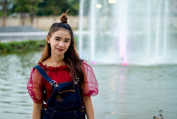 Women white skin lovely wear lace shirt red wear jeans dungarees blue women standing poses photography portrait has a curtain fountain as a background.