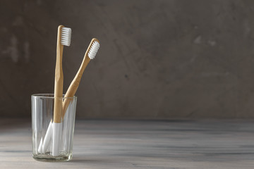 Two eco friendly bamboo tooth brushes in a glass