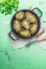 Baked potatoes in black frying pan with pesto sauce