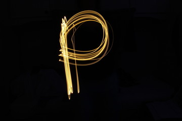 Long exposure, light painting photography.  Letter p in a vibrant neon metallic yellow gold colour against a black background.  Alphabet series.