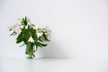Simple bouquet with Alstroemeria flowers and empty white wall