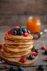 Pancakes with berries and maple syrup and sugar powder