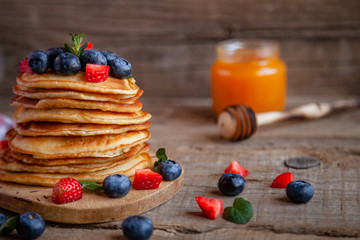 Pancakes with berries and maple syrup and sugar powder