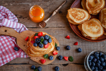Pancakes with berries and maple syrup and sugar powder