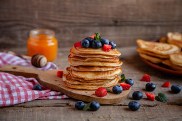 Pancakes with berries and maple syrup and sugar powder