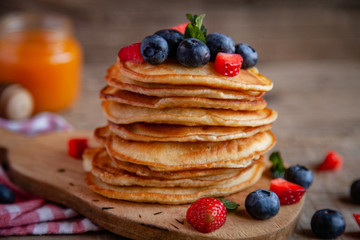 Pancakes with berries and maple syrup and sugar powder