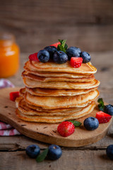 Pancakes with berries and maple syrup and sugar powder