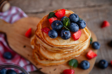 Pancakes with berries and maple syrup and sugar powder