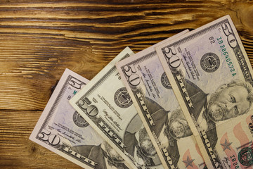 Fifty dollars banknotes on wooden background. Top view