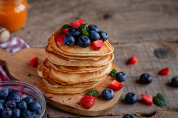 Pancakes with berries and maple syrup and sugar powder
