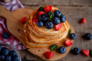 Pancakes with berries and maple syrup and sugar powder