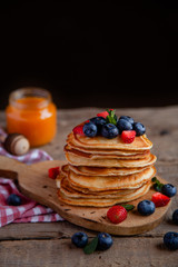 Pancakes with berries and maple syrup and sugar powder