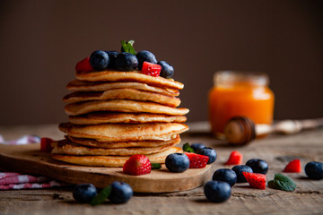 Pancakes with berries and maple syrup and sugar powder