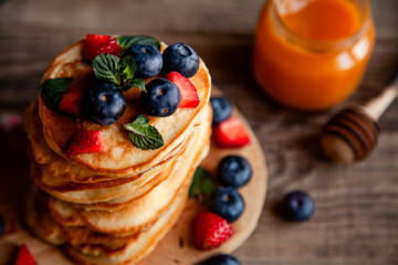 Pancakes with berries and maple syrup and sugar powder