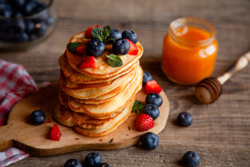 Pancakes with berries and maple syrup and sugar powder