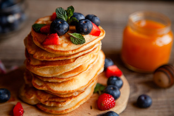 Pancakes with berries and maple syrup and sugar powder