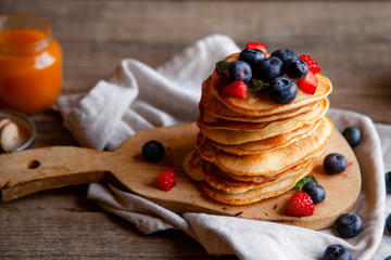 Pancakes with berries and maple syrup and sugar powder