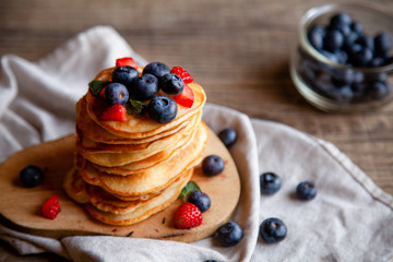 Pancakes with berries and maple syrup and sugar powder