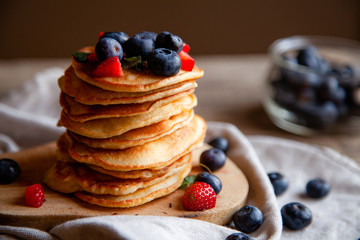 Pancakes with berries and maple syrup and sugar powder