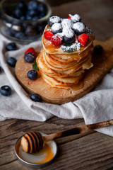 Pancakes with berries and maple syrup and sugar powder