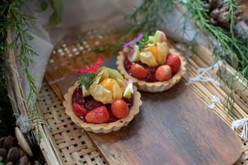 Mixed fruit tarts on bamboo dishes.
