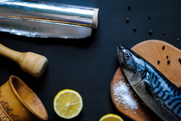 Mackerel, foil, salt, pepper and lemon on the table