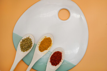 Spices in wooden spoons on background. Pepper chilly, basil, curry. Concept of organic food. top view.