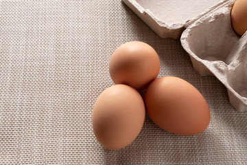 Close-up view of fresh brown eggs in the box to prevent it from cracking. Was put on a brown canvas to wait for cooking.
