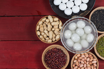 sweet dumplings in bowl on table, ang pow or red packet and gold ingots