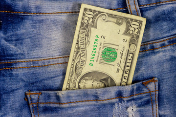 Twenty dollars bill in the pocket of blue jeans