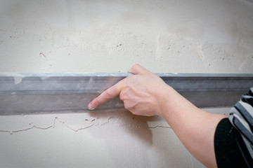 Renovation at home. Plasterer spreading plaster on wall. Who plaster wall plaster master.