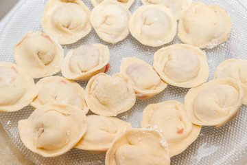 Fototapeta na wymiar Raw and fresh dumplings lie on a glass plate