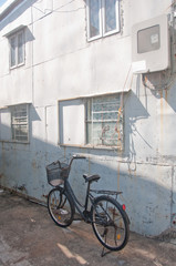 Fototapeta na wymiar Old black classical vintage family bicycle parks near an old hou
