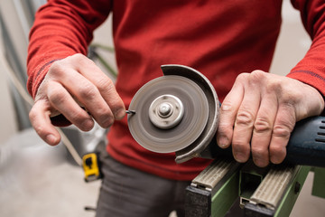 worker sharpening a drill with a grinder