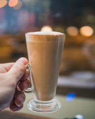 glass of coffee drink. Coffee latte, macchiato. coffee mocha near the window. blurred background