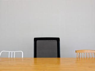 group of wood metal and office chairs with wood table in light gray meeting room in minimal composition