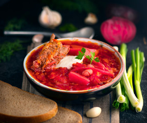 Traditional Ukrainian russian borscht. Plate of red beet root soup borsch on black rustic table. Beetroot soup. Traditional Ukrainian cuisine