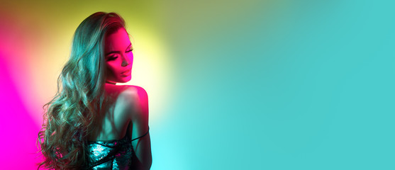 Fashion model brunette woman in colorful bright neon lights posing in studio. Beautiful sexy girl,...