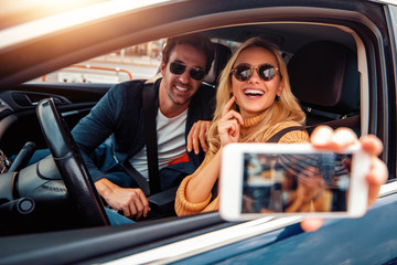 Happy couple in car on road trip smiling at each other