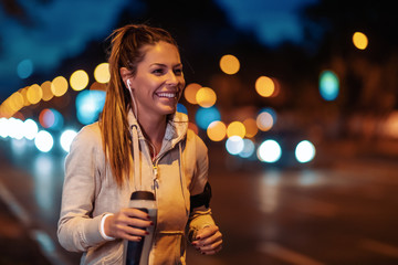 Young woman jogging at night in the city