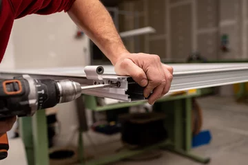 Foto op Aluminium close up of a man hands assembling with a drill a piece of aluminum © oscar