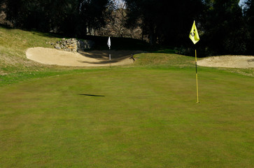 Obraz premium Golf course with flag stick on a sunny day