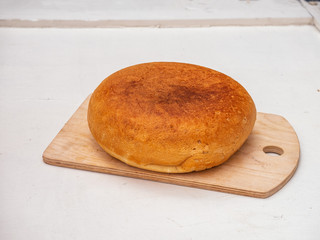freshly baked homemade round bread on a wooden kitchen board