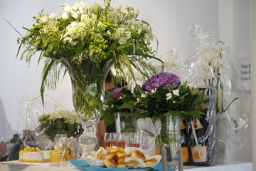 Decorated table with cake, champagne and purple white flowers for a birthday