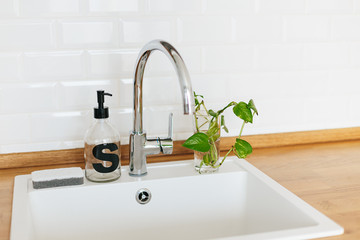 White sink soap dispenser wooden countertop and white ceramic brick tile background