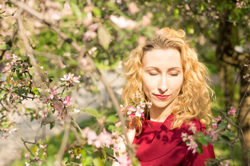 Naklejka premium portrait of girl. girl the blonde. girl near cherry blossoms