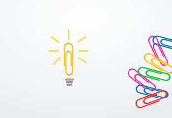 yellow paperclip on paper next to paperclips as a symbol of a light bulb. business idea concept