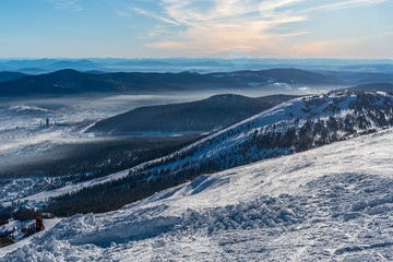View of ski resort Sheregesh in Siberia with town in a valley and mountains on the horizon